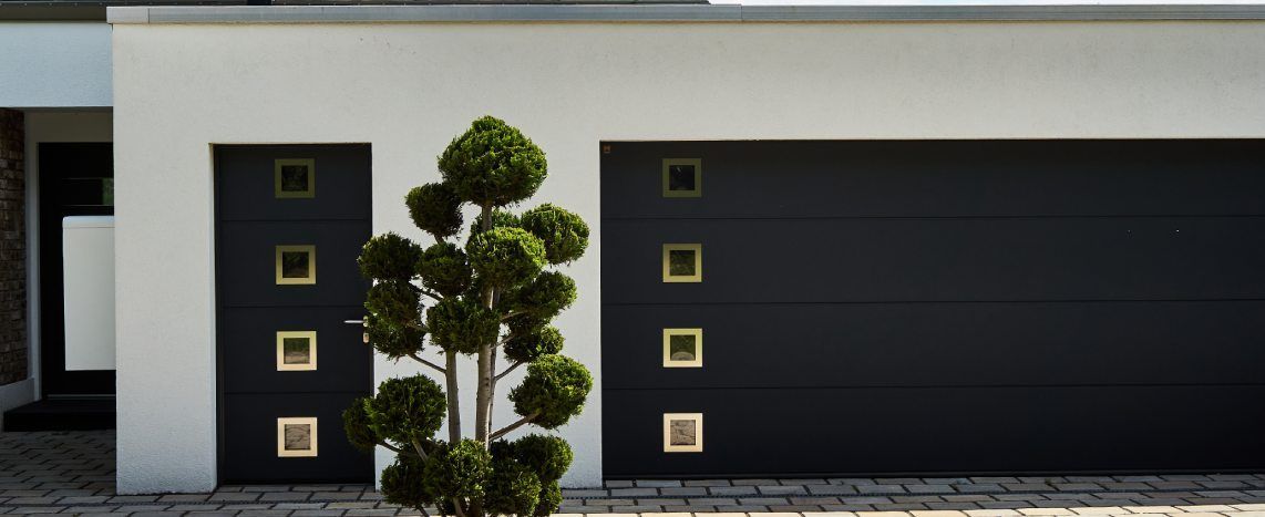 Black modern garage door with horizontal panels installed on a light-colored residential exterior.