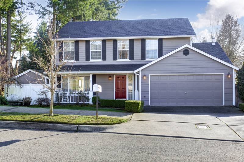 Suburban two-story home with a single lavender garage door and a neatly maintained front lawn.