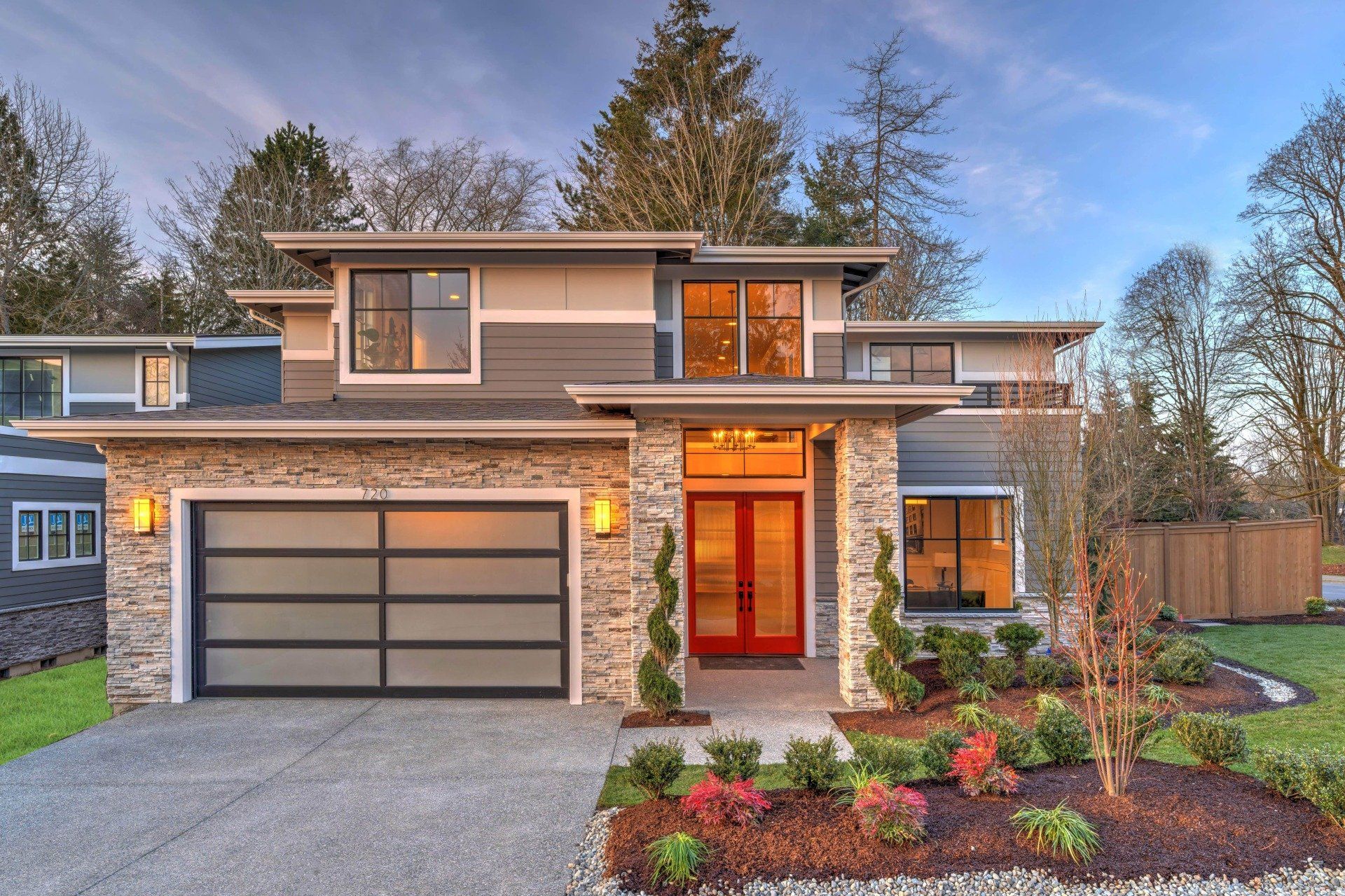 Matching white garage doors complementing home exterior, installed for energy efficiency by Tri-Lakes Garage Doors team.