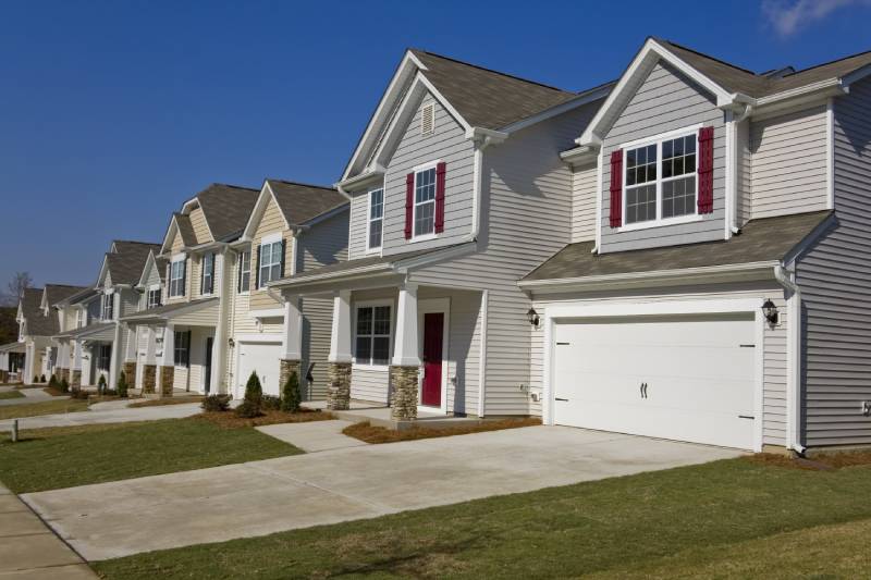 Row of suburban homes featuring varying styles of garage doors, from single to double for modern look.