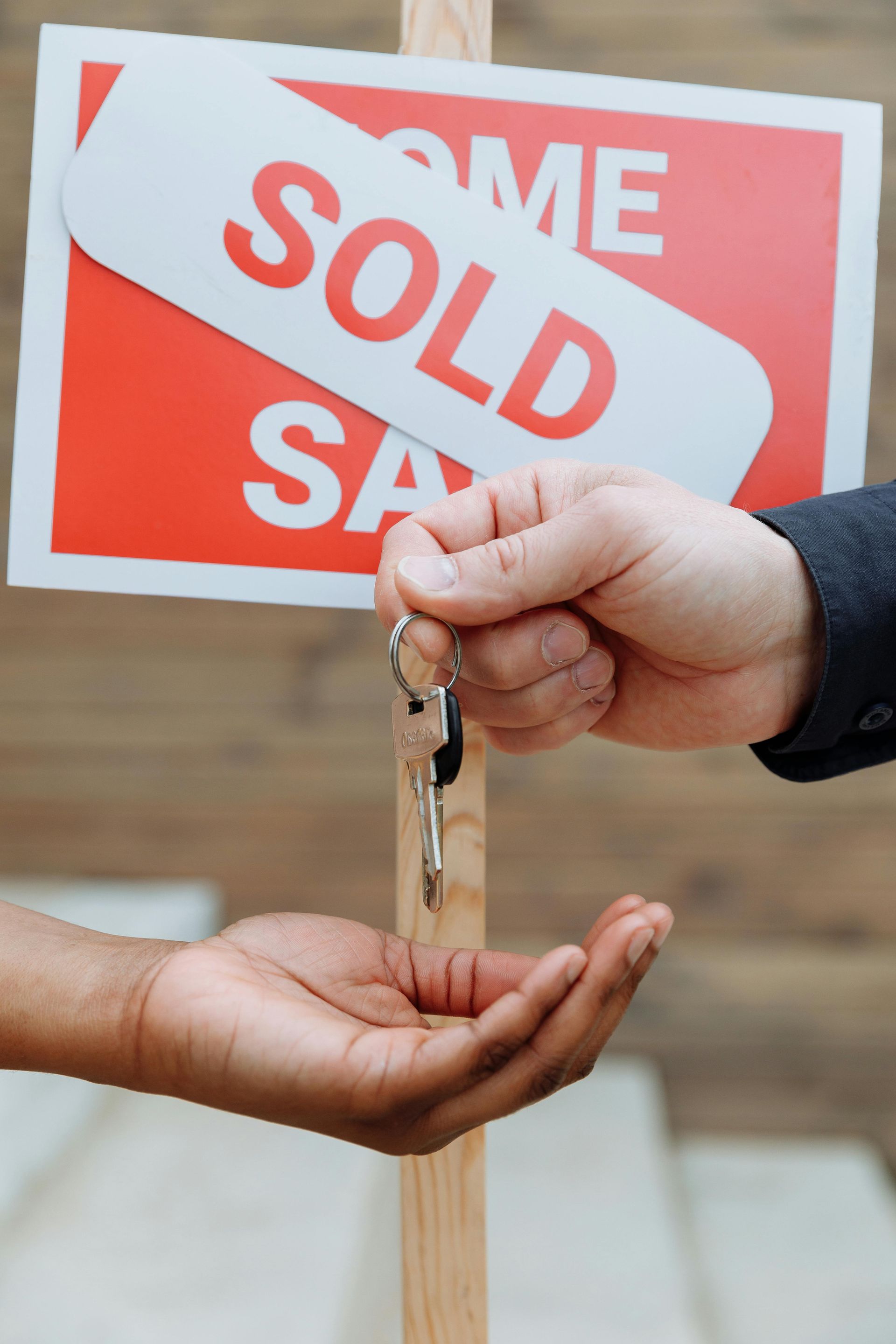 Hands exchanging keys in front of a
