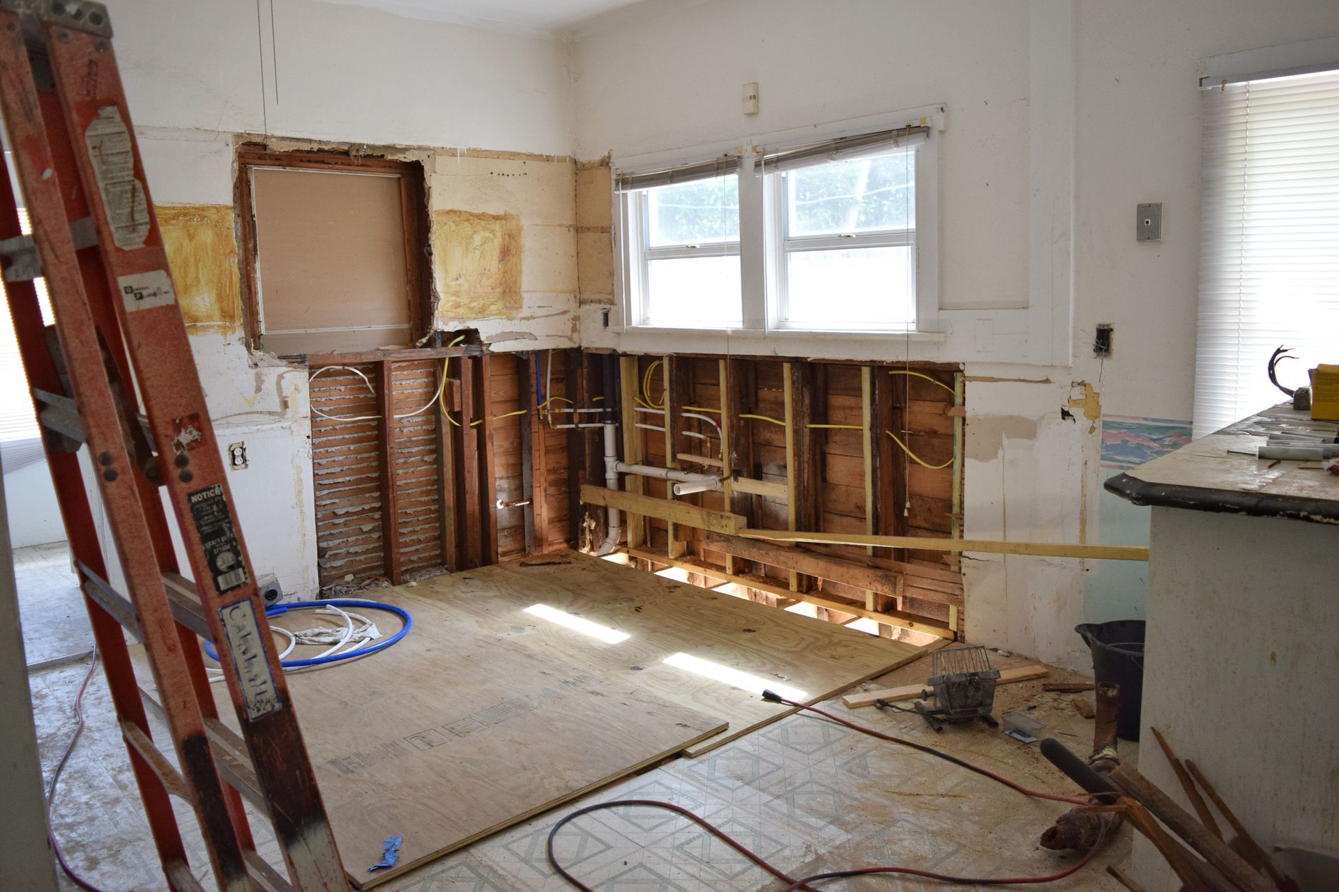 A kitchen under construction with a ladder in the foreground.