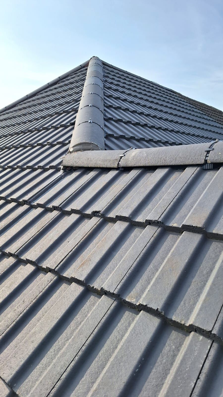 A close up of a roof with a blue sky in the background.