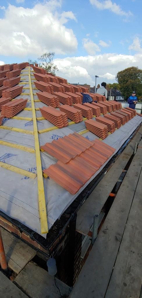 A roof with a lot of tiles on it is being built.