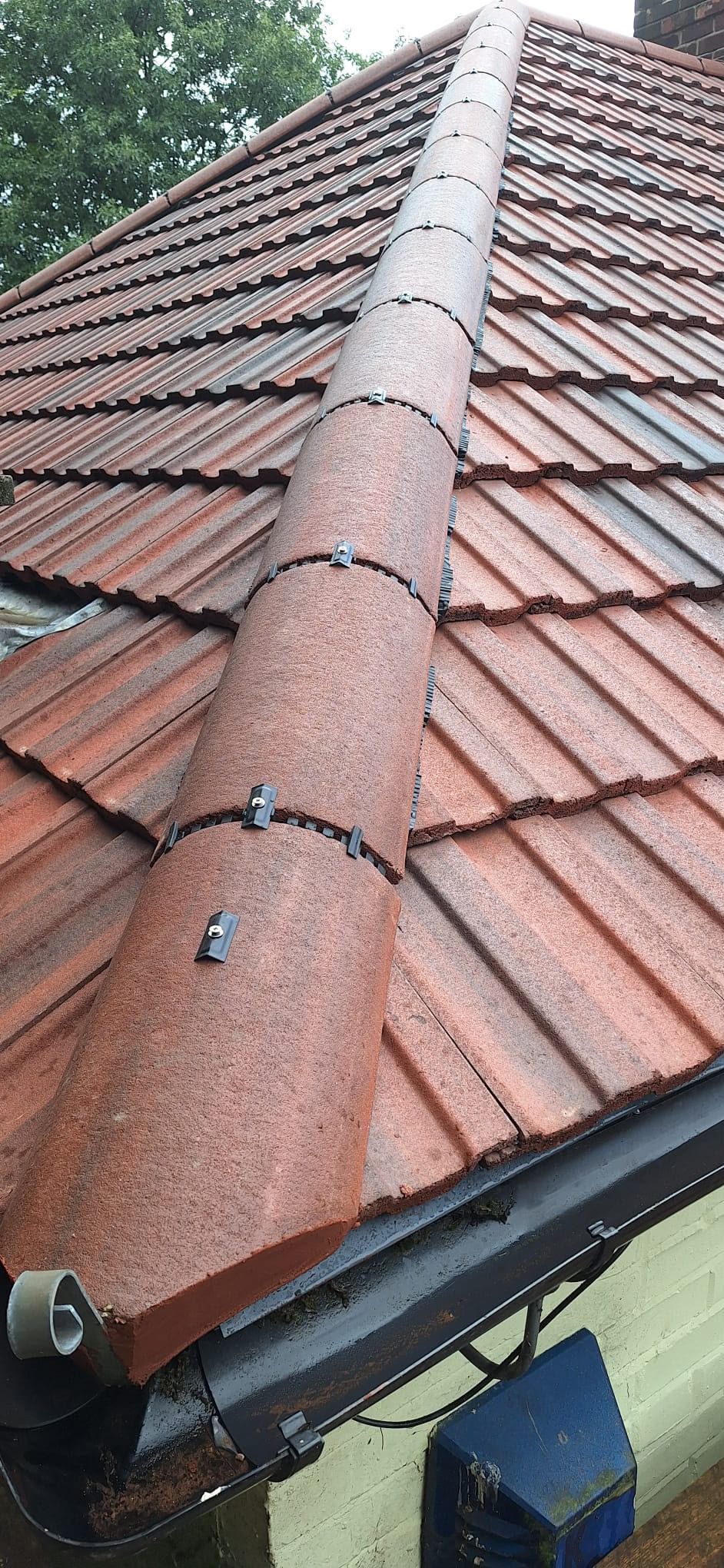 Red tiled roof with a metal ridge vent and gutter, viewed from above