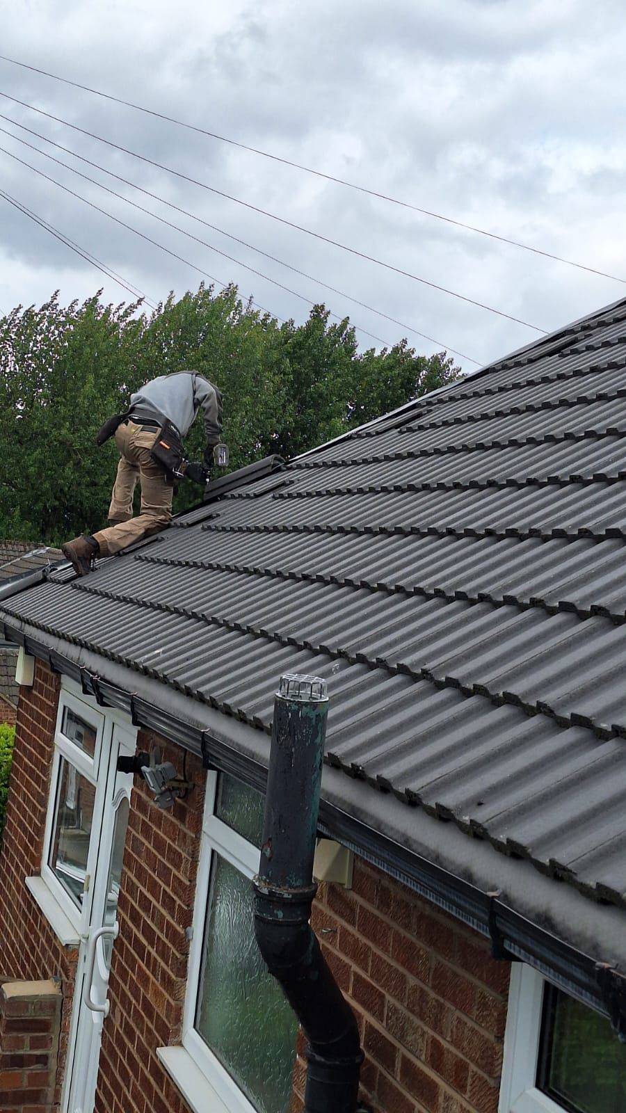 A man is working on the roof of a house.