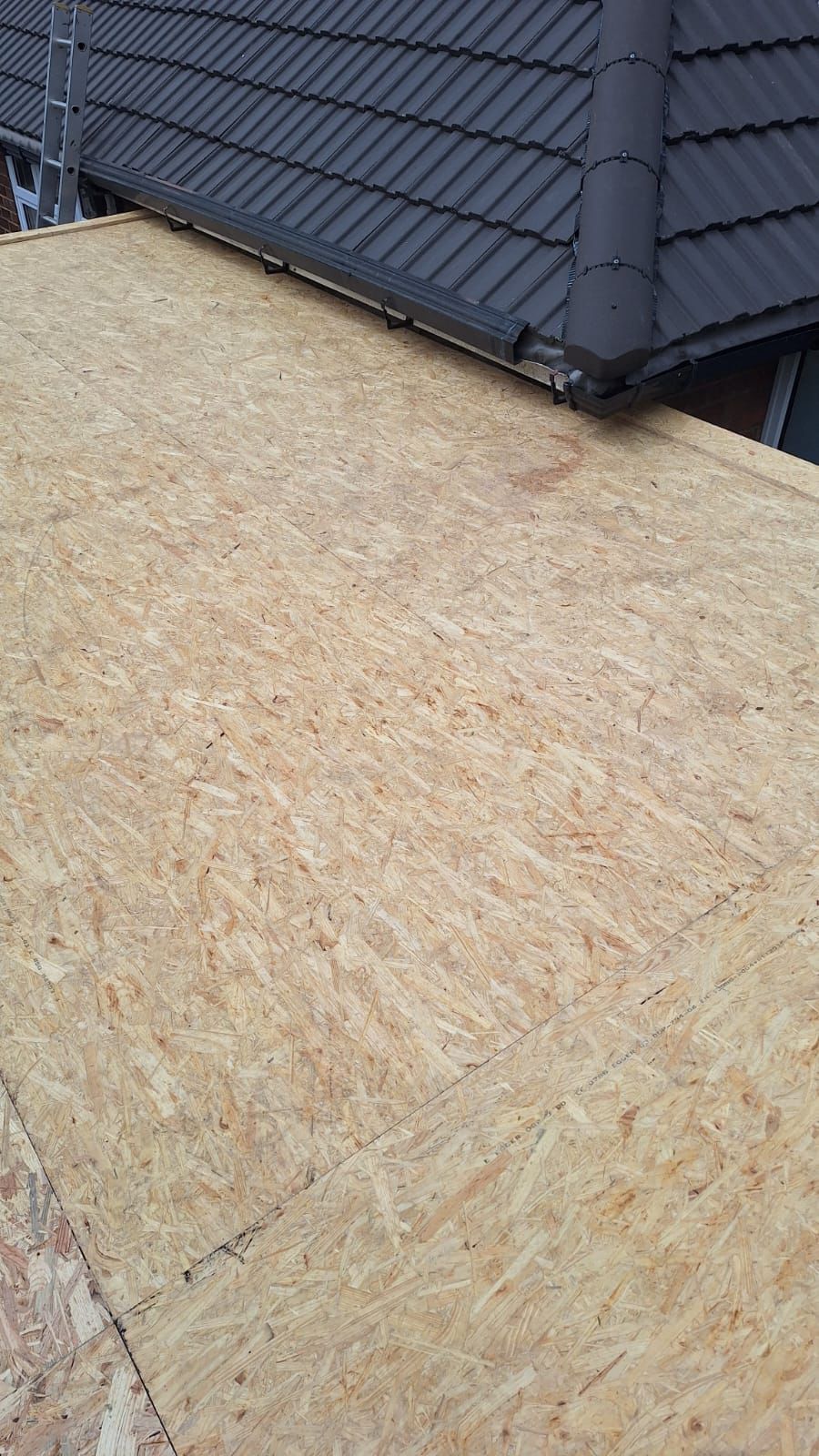 A wooden roof is being built on top of a house.