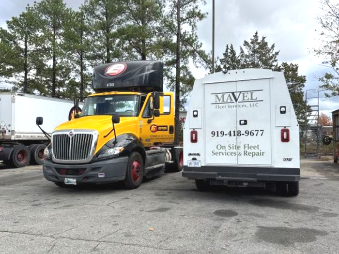 Yellow truck next to white service vehicle;
