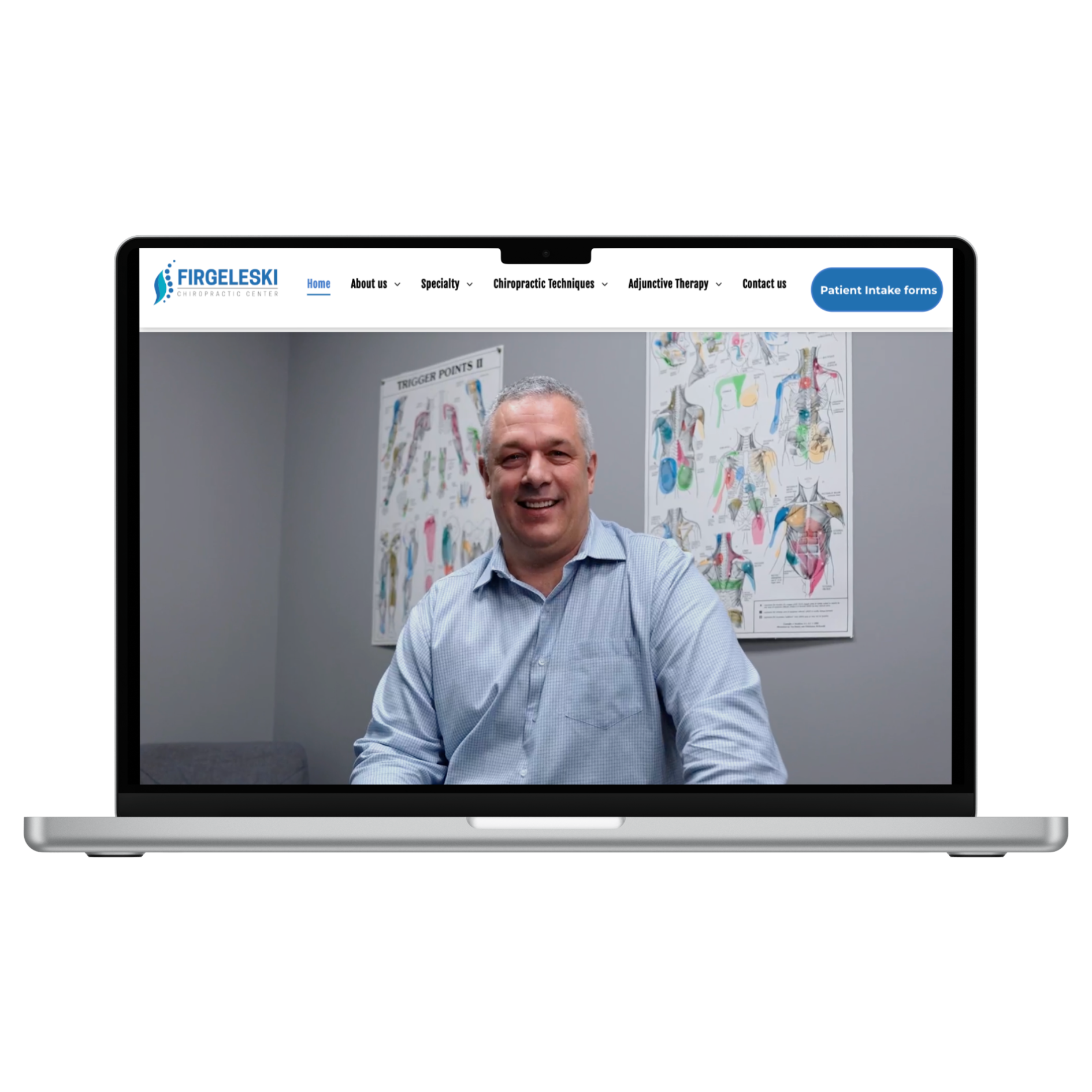 A laptop screen displays a man smiling in a room with anatomical charts on the wall and a navigation menu at the top.