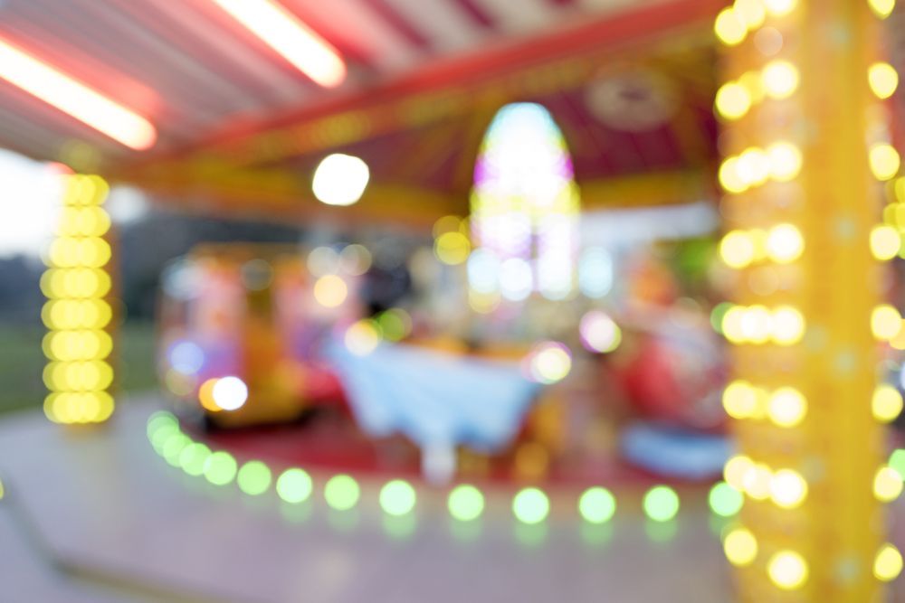 Carousel with blurred lights, illuminated in yellow, green, and red.