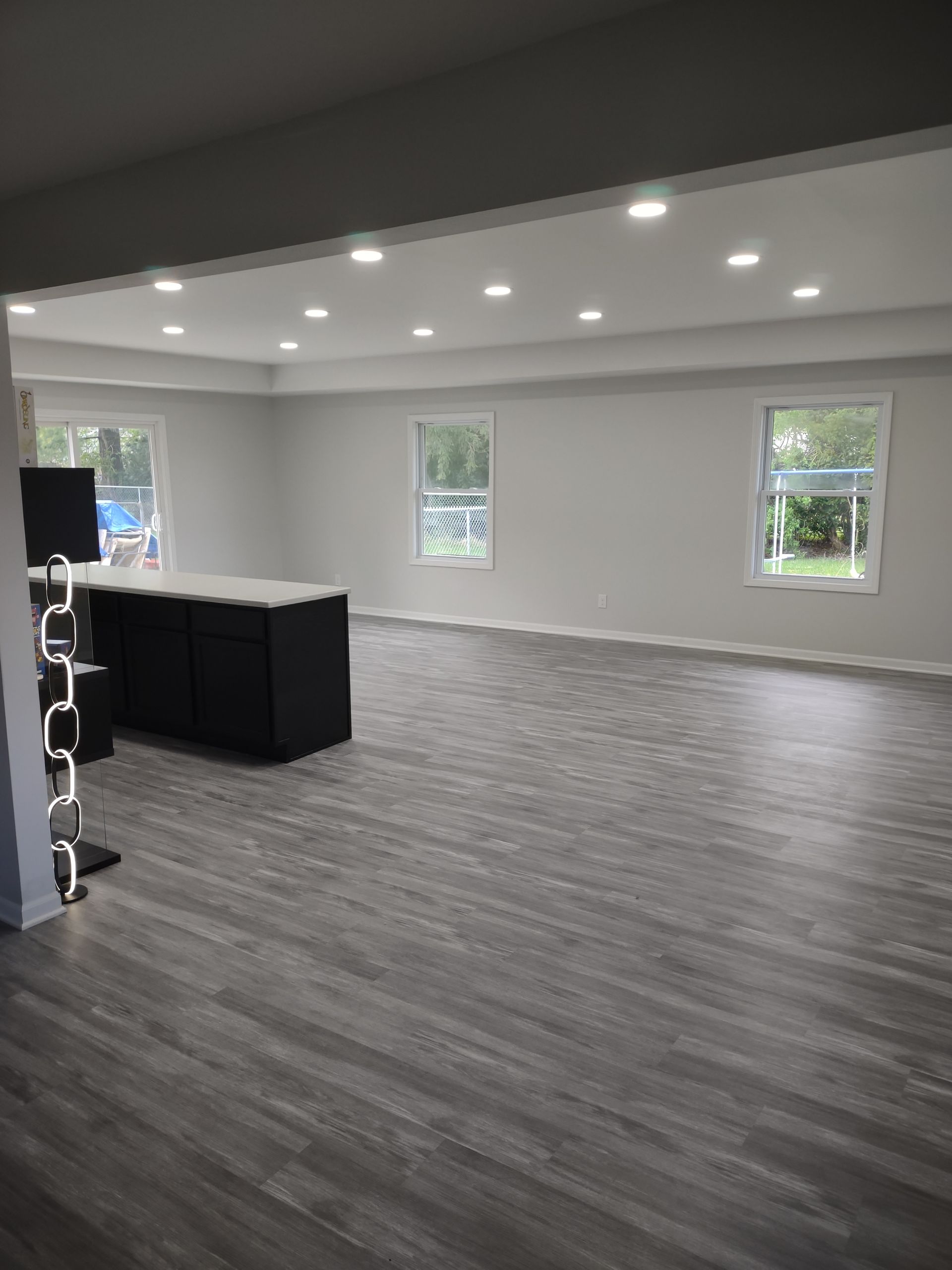 A large empty room with hardwood floors and white walls.