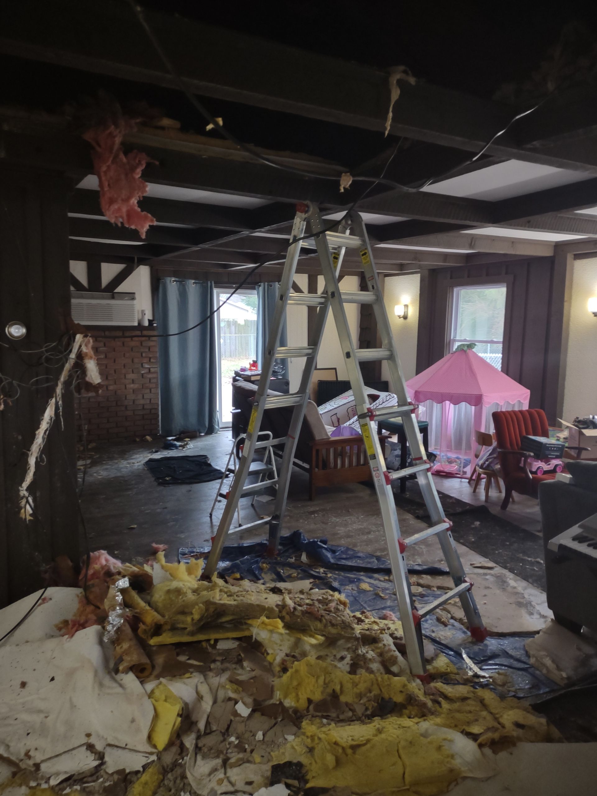 A ladder is sitting in the middle of a living room.