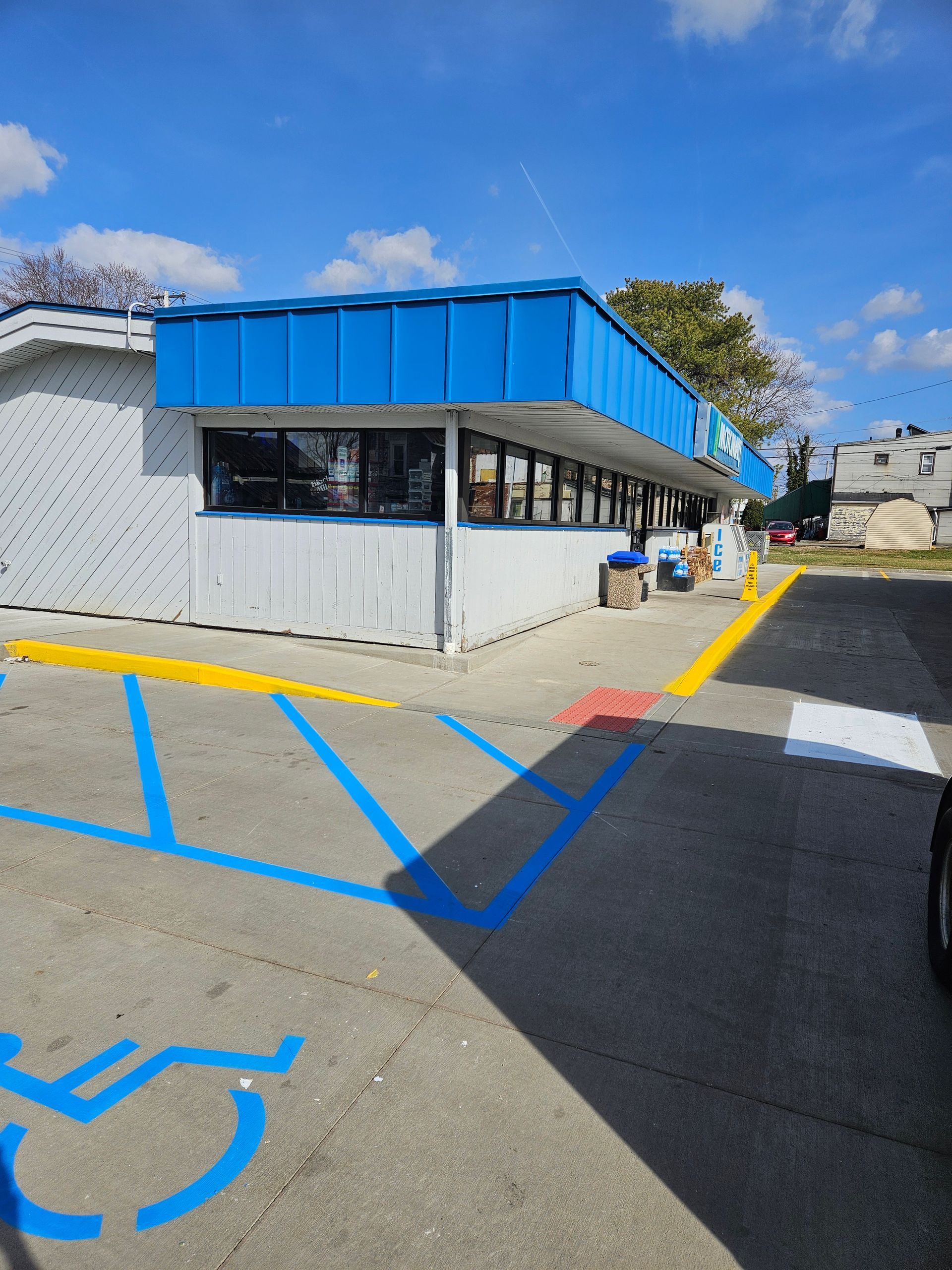 A blue and white building with a handicapped parking spot in front of it