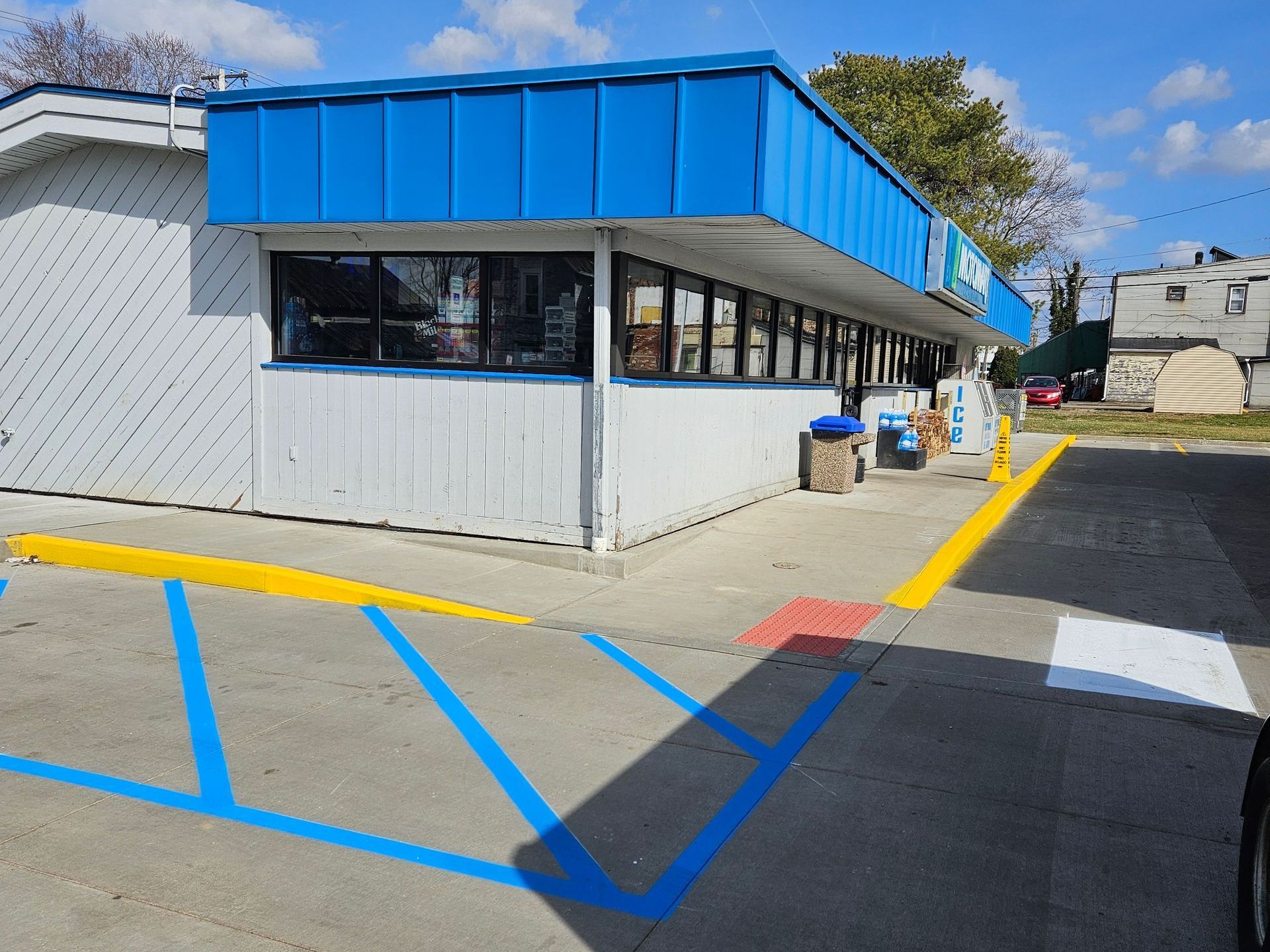 A blue and white building with a parking lot in front of it