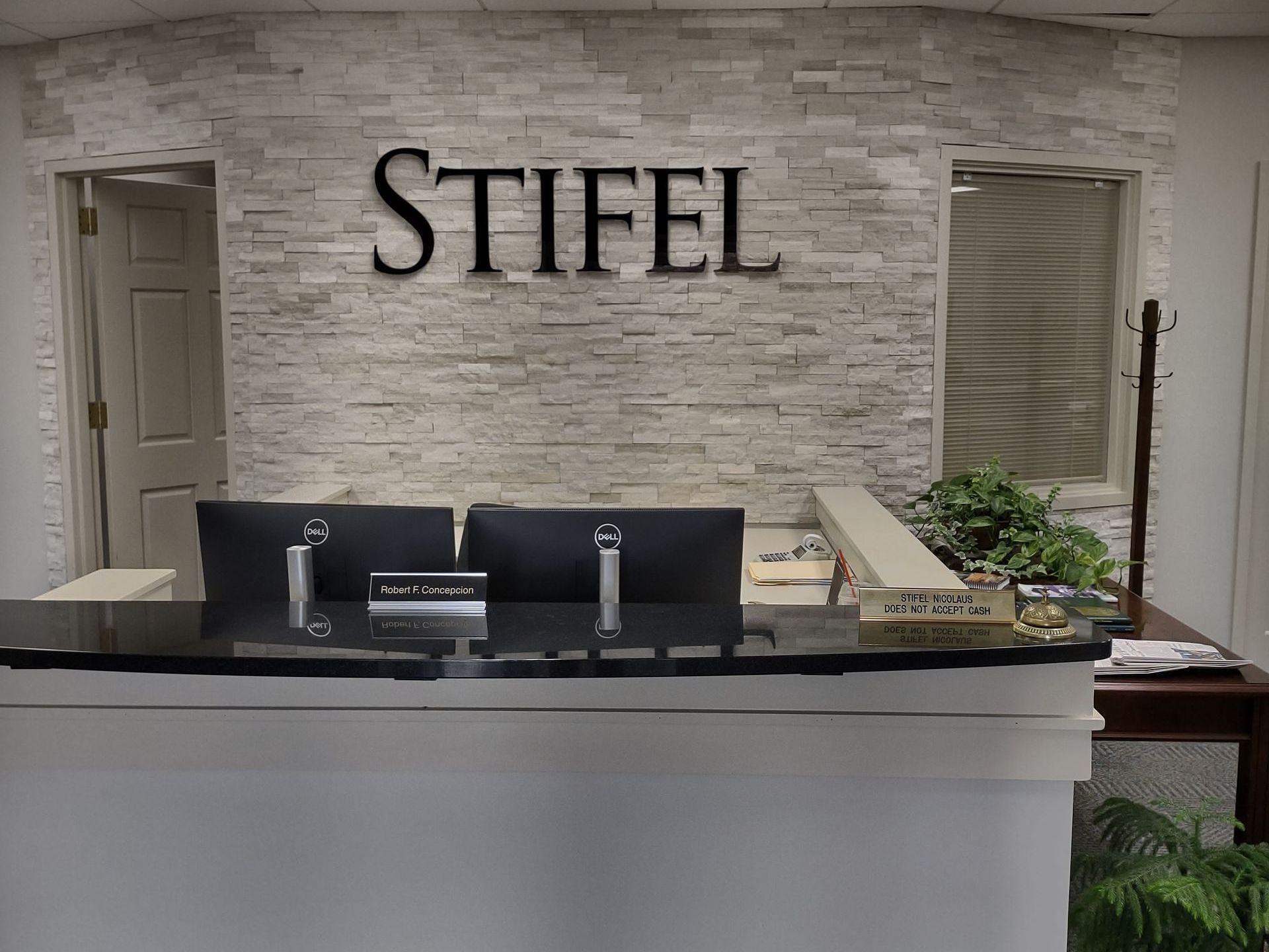 A reception desk with a sign that says stifel on it.