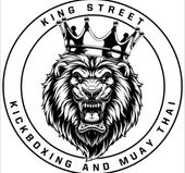 A black and white logo for king street kickboxing and muay thai with a lion wearing a crown.