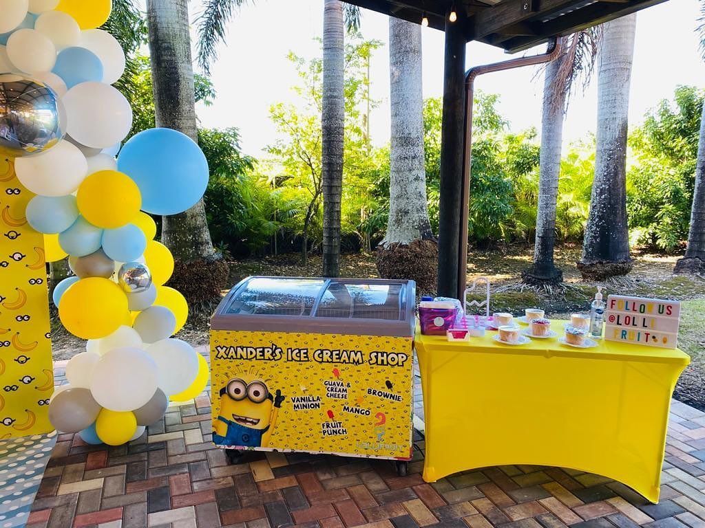 A yellow table with a yellow table cloth is sitting next to a yellow ice cream machine.