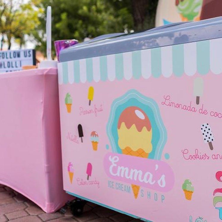A pink emma 's ice cream shop cart with ice cream on it