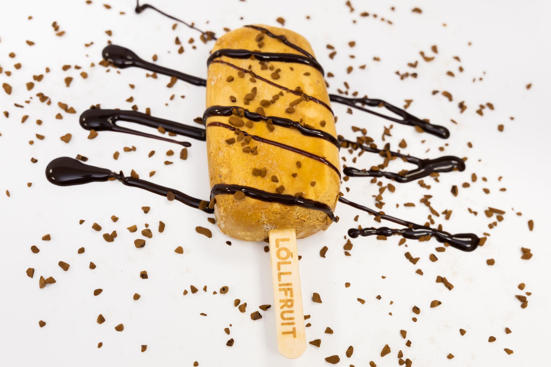 A lollipop with chocolate sauce and sprinkles on it
