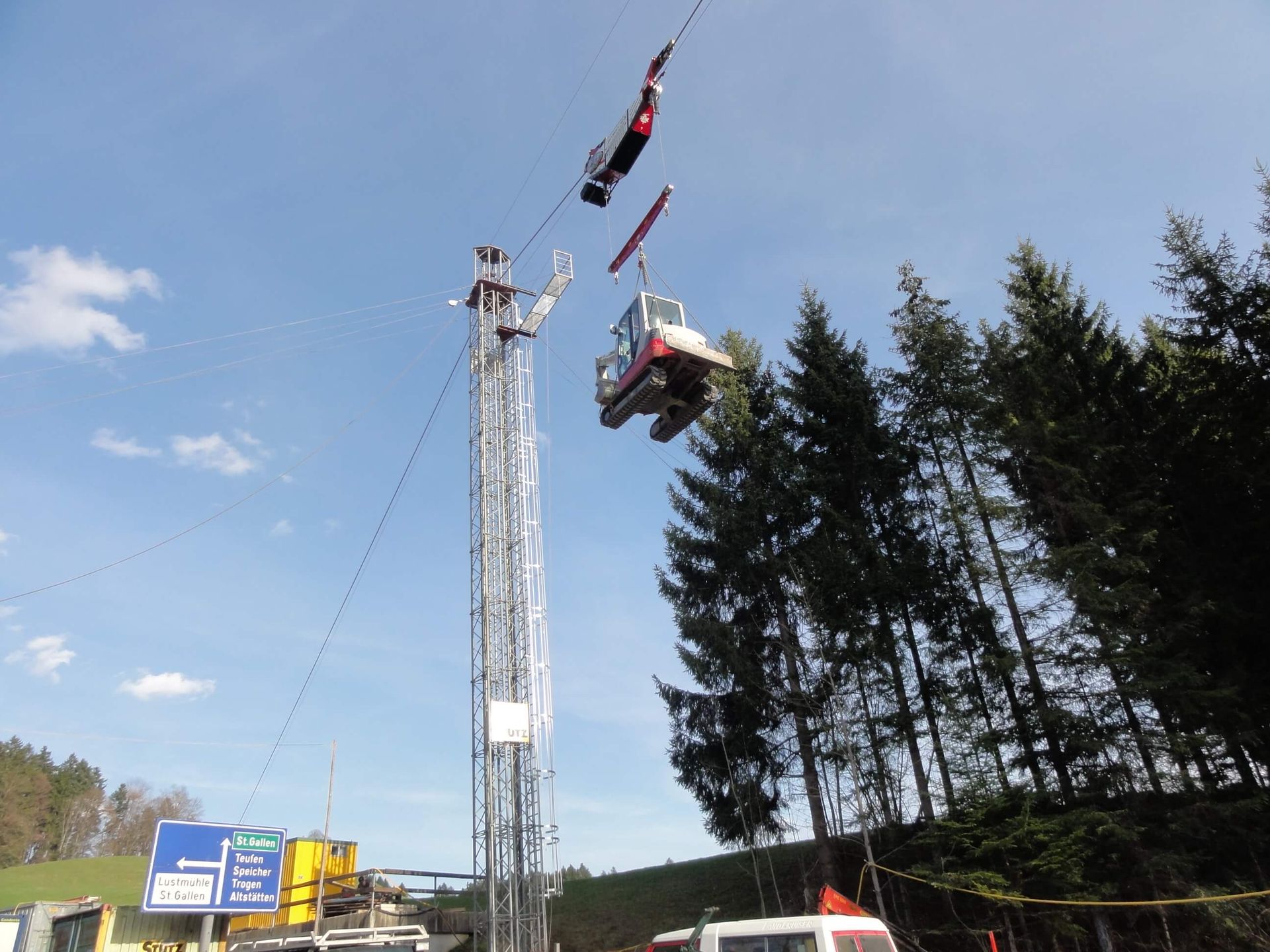 Eine große Maschine fliegt mit einem Kabelkran durch die Luft.