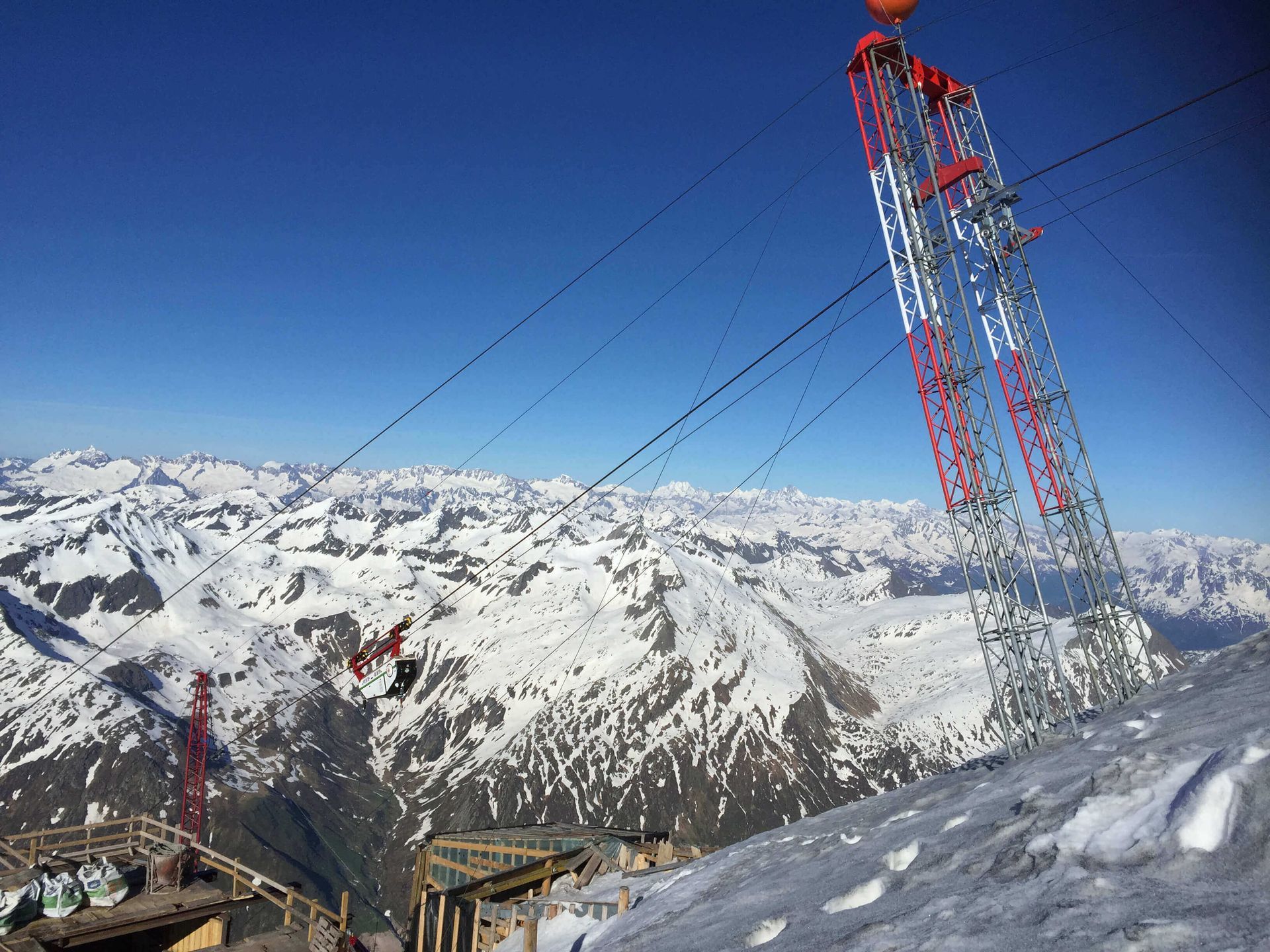 Eine Materialseilbahn fährt einen schneebedeckten Berg hinauf.