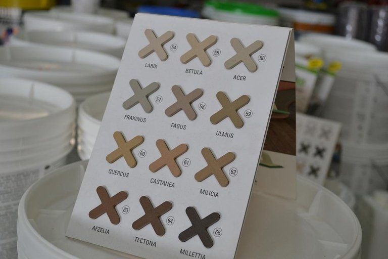 Campioni di colore esposti. Campioni di vernice beige, marrone e marrone chiaro disposti a croce con etichette: Sfumato, Etna, Adige e altri.