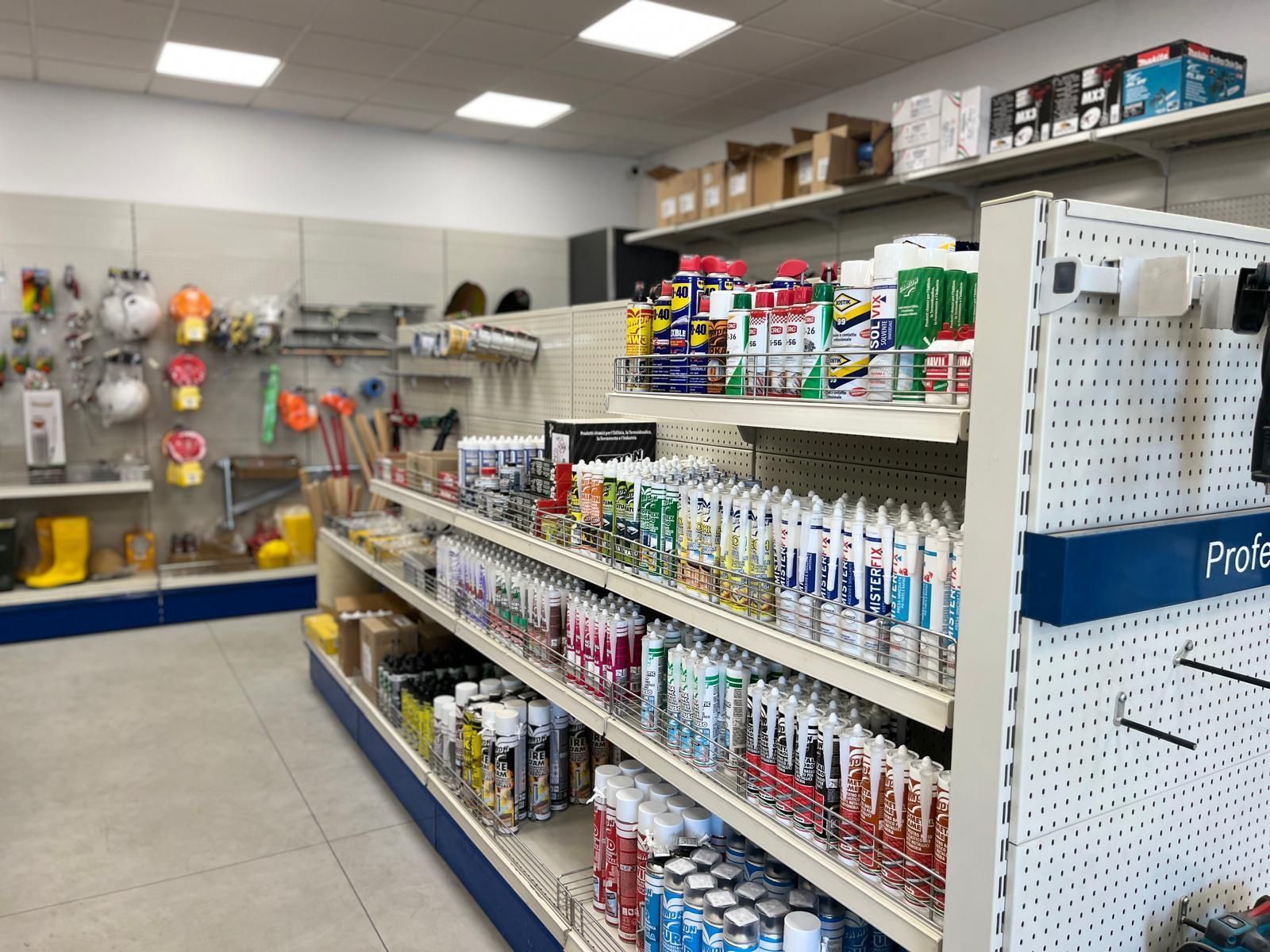 Interno di un negozio di ferramenta con scaffali pieni di vari utensili e forniture.