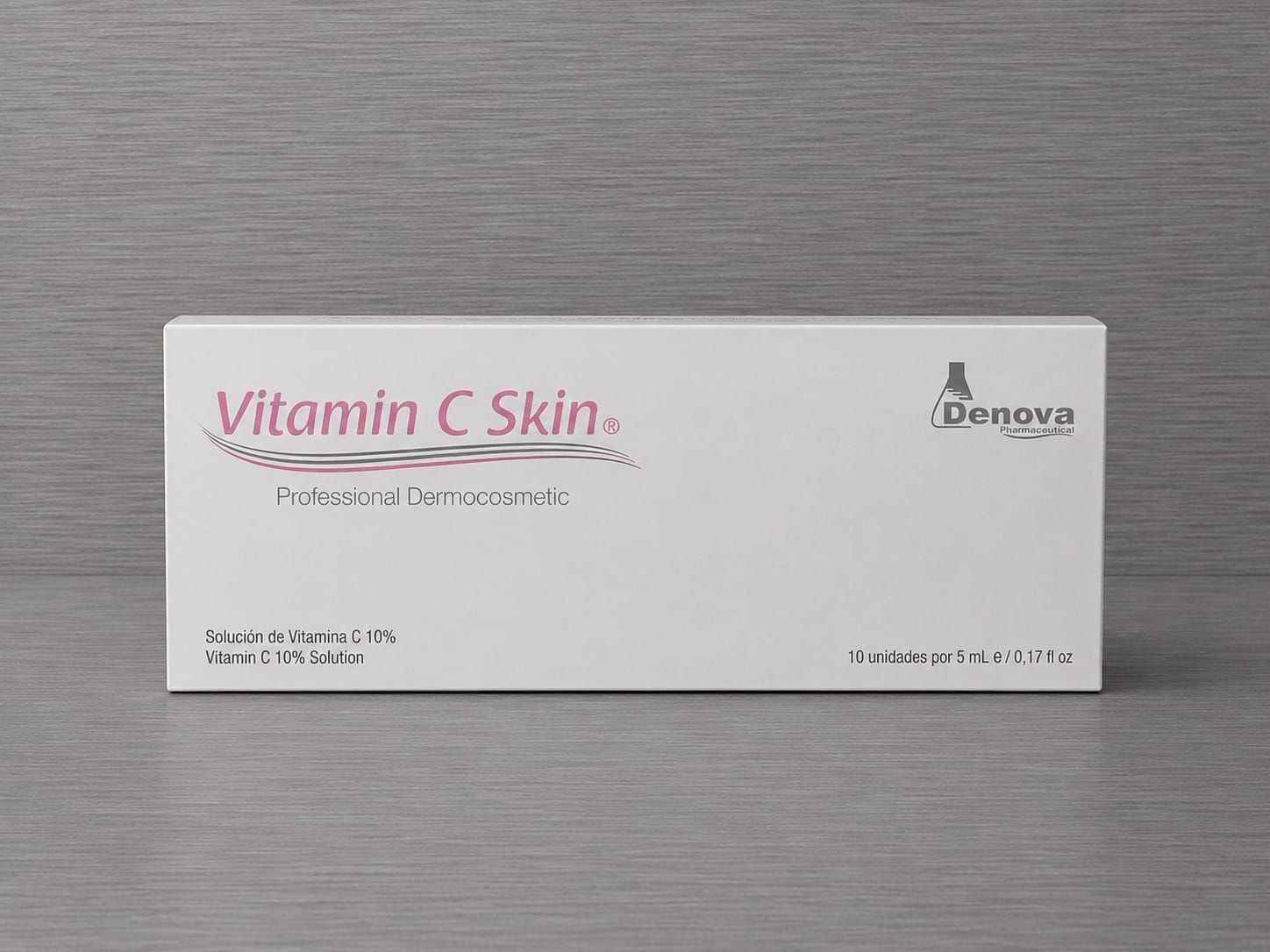 Caja blanca de producto para el cuidado de la piel con vitamina C sobre una superficie gris con texto rosa y negro.