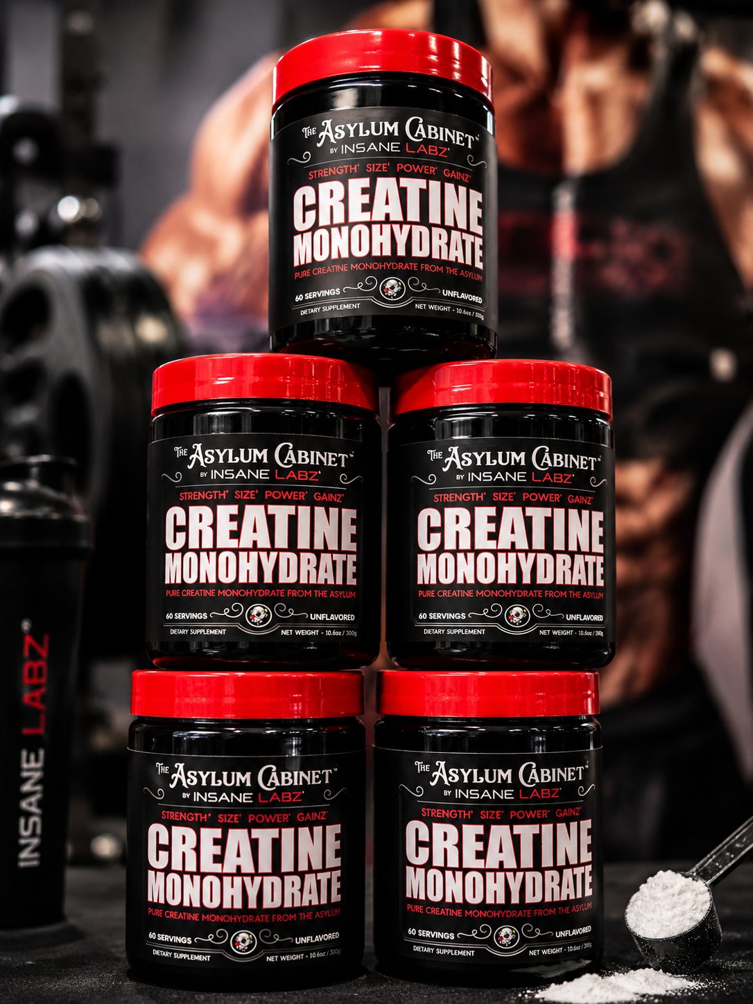 Pila de botes de suplemento de monohidrato de creatina de color negro y rojo en el suelo de un gimnasio,