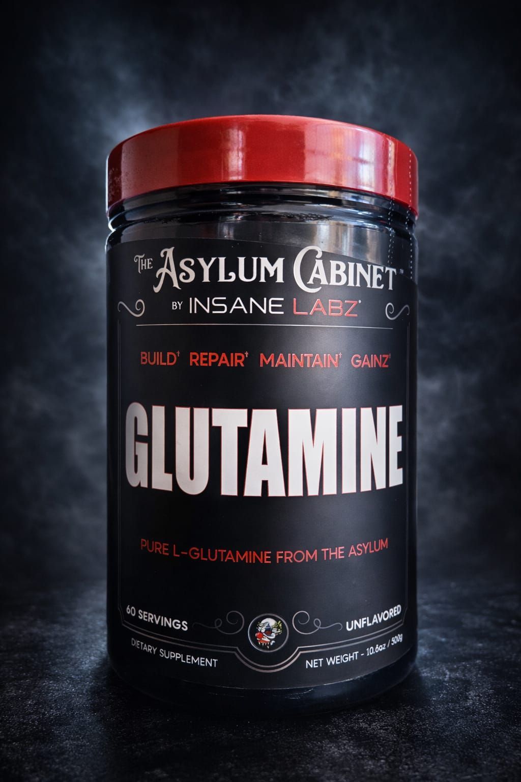 Frasco de suplemento negro con la etiqueta “GLUTAMINA” y tapa roja sobre fondo oscuro.