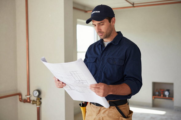 J Repiping & Builders founder reviewing a repiping plan on a San Fernando Valley job site.