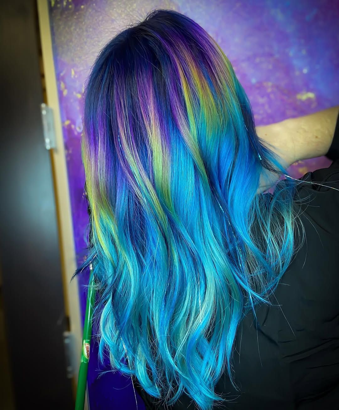 Hair dyed in shades of blue, purple, and green.