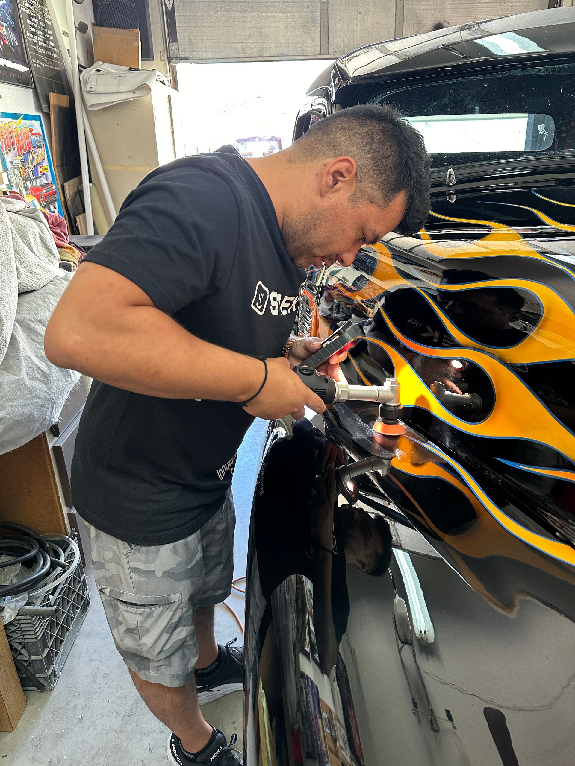 Professional detailer using dual-action polisher on vehicle paint