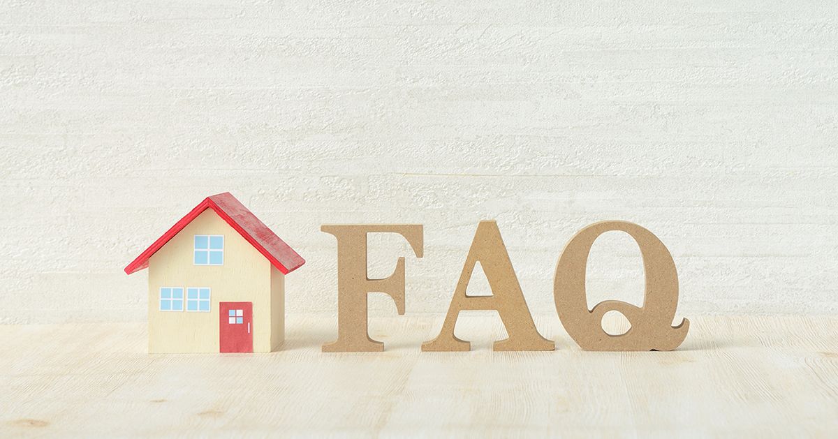 Neben einem kleinen Haus steht in Holzbuchstaben das Wort „FAQ“.