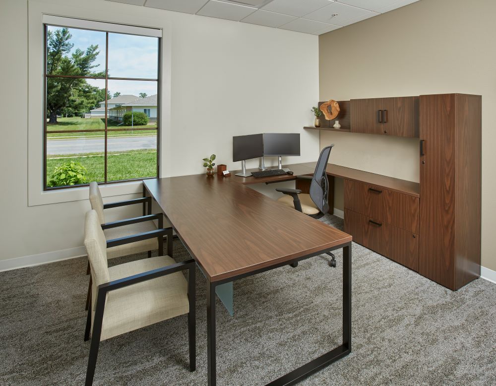 A conference room with a large wooden table and chairs.