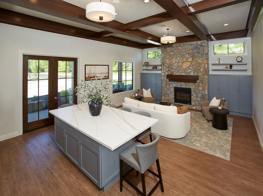 A living room with a large island in the middle and a fireplace.