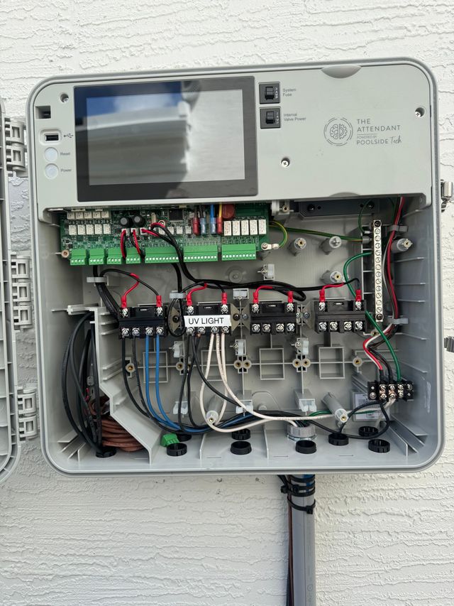 Electrical panel open, tools on table. Laundry room setting with washing machine.