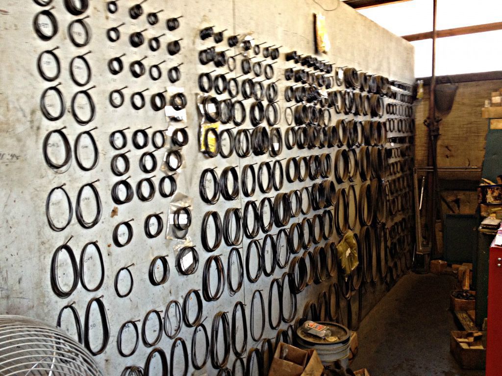 Wall covered with various sizes of black circular rubber seals, likely for machinery parts, organized in rows.