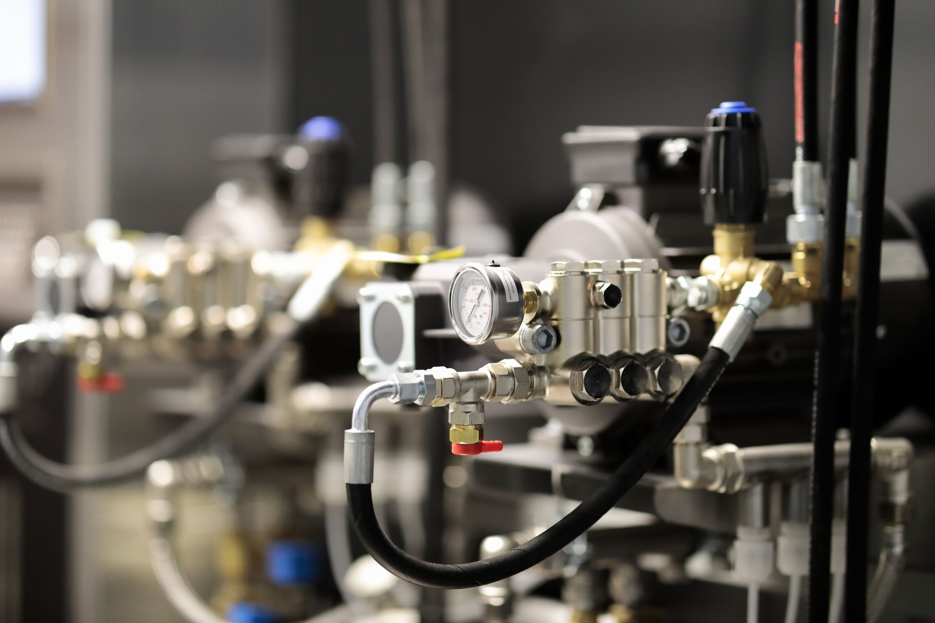 Close-up of industrial machinery with gauges, valves, and metal tubing.