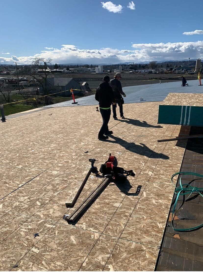 Crew from Yakima Roofing & Remodeling resheeting roof with 7/16 OSB panels at Decco USA in Yakima.