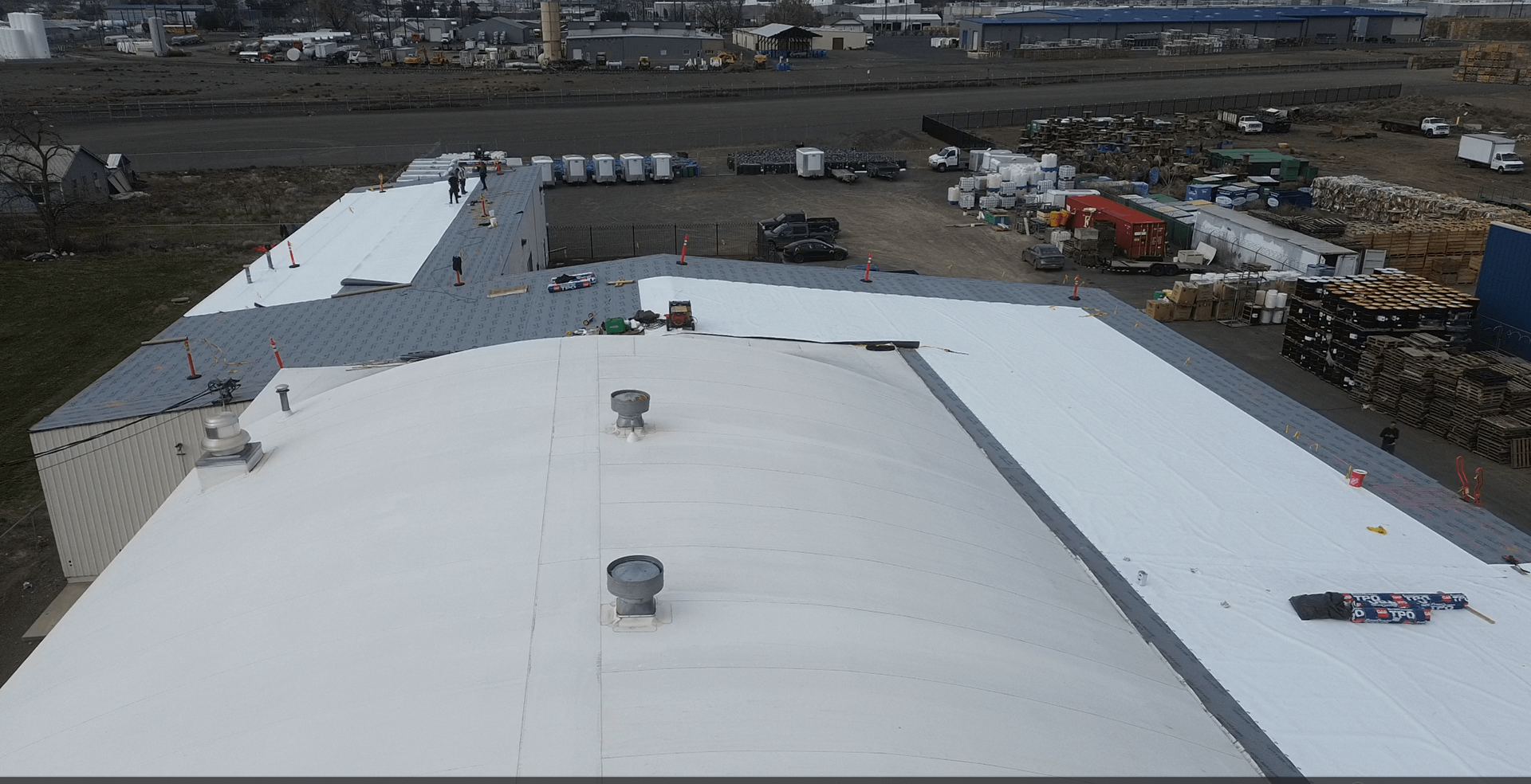 Aerial view of TPO roof installation showing new white membrane and the working crew at Decco USA in Yakima.