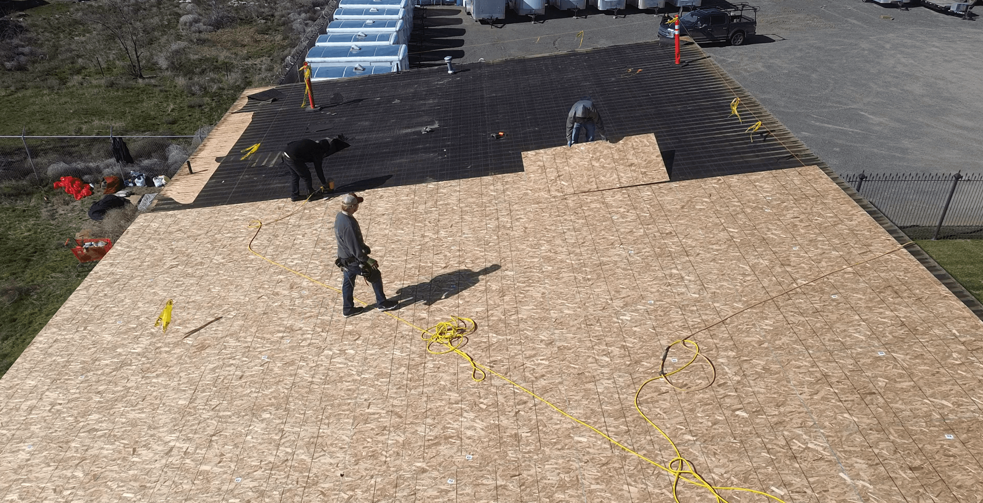 Crew members installing OSB sheeting over a metal roof at Decco USA in Yakima.