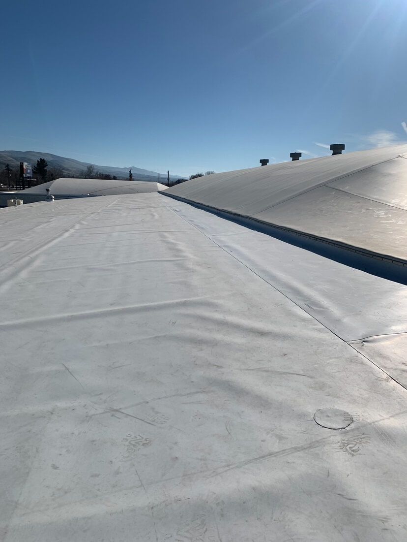 Completed TPO roof section with vents and clean seams, part of a commercial roofing project by Yakima Roofing & Remodeling.