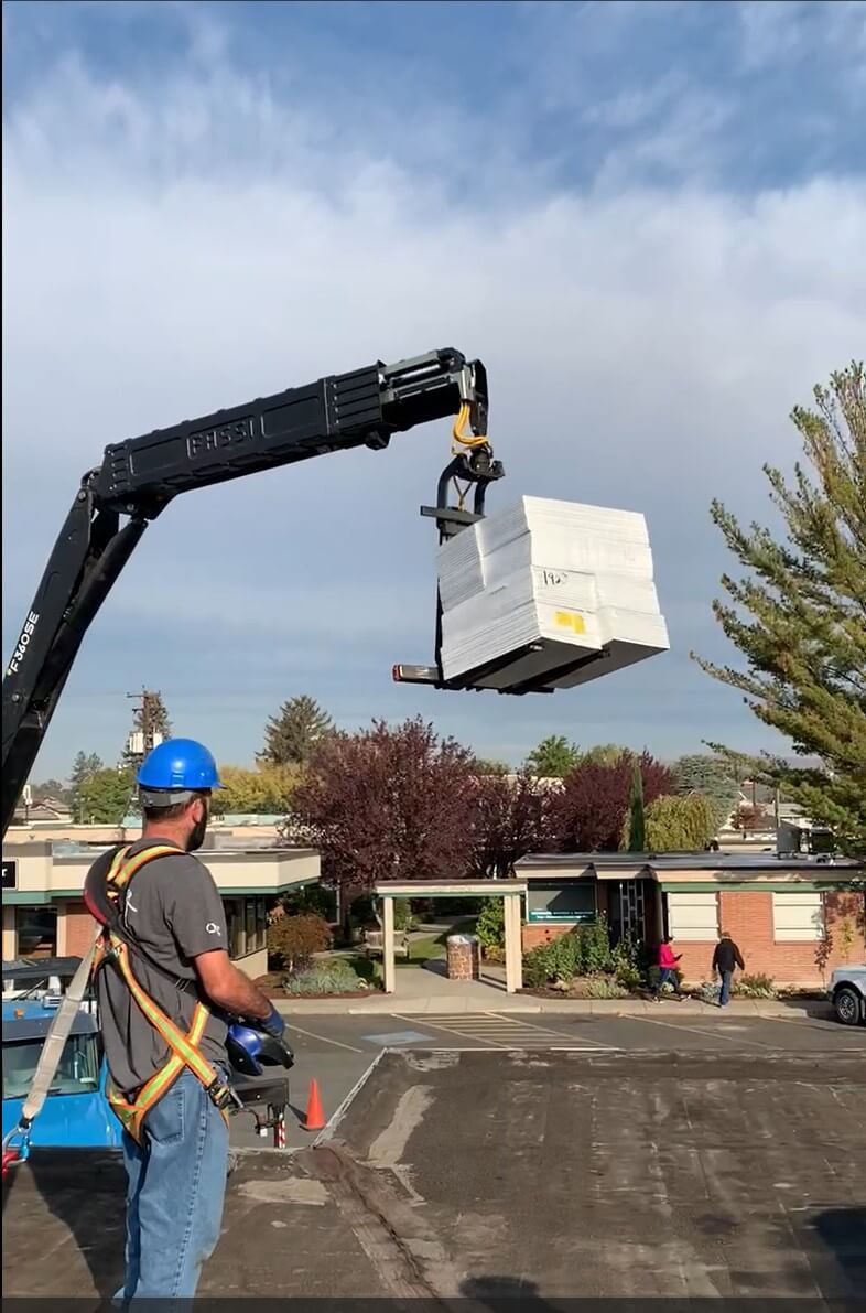 Lifting a pallet of TPO roofing materials onto the Labcorp building roof in Yakima.