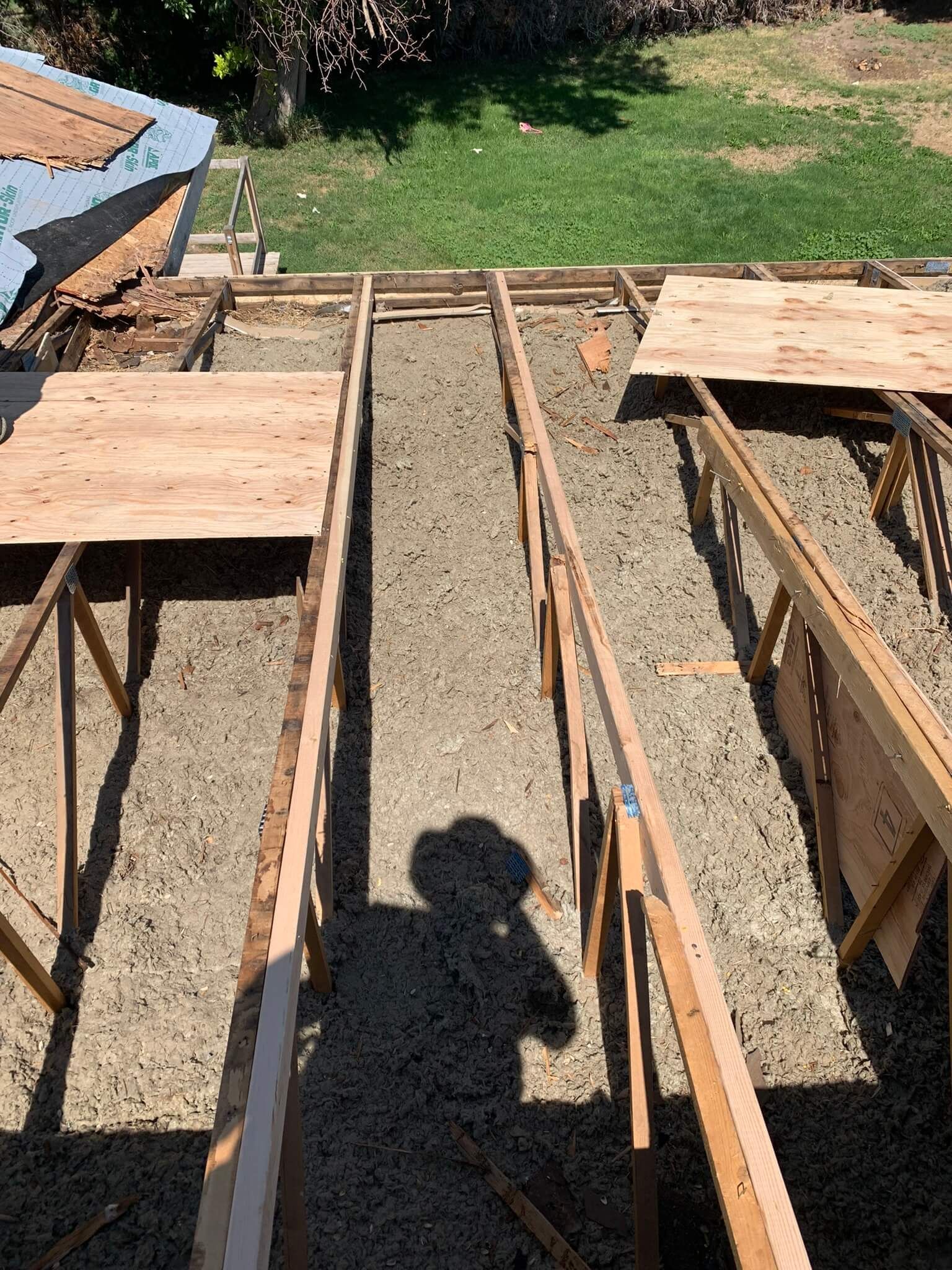 Manufactured home's roof structure exposed after tear-off, with trusses visible.
