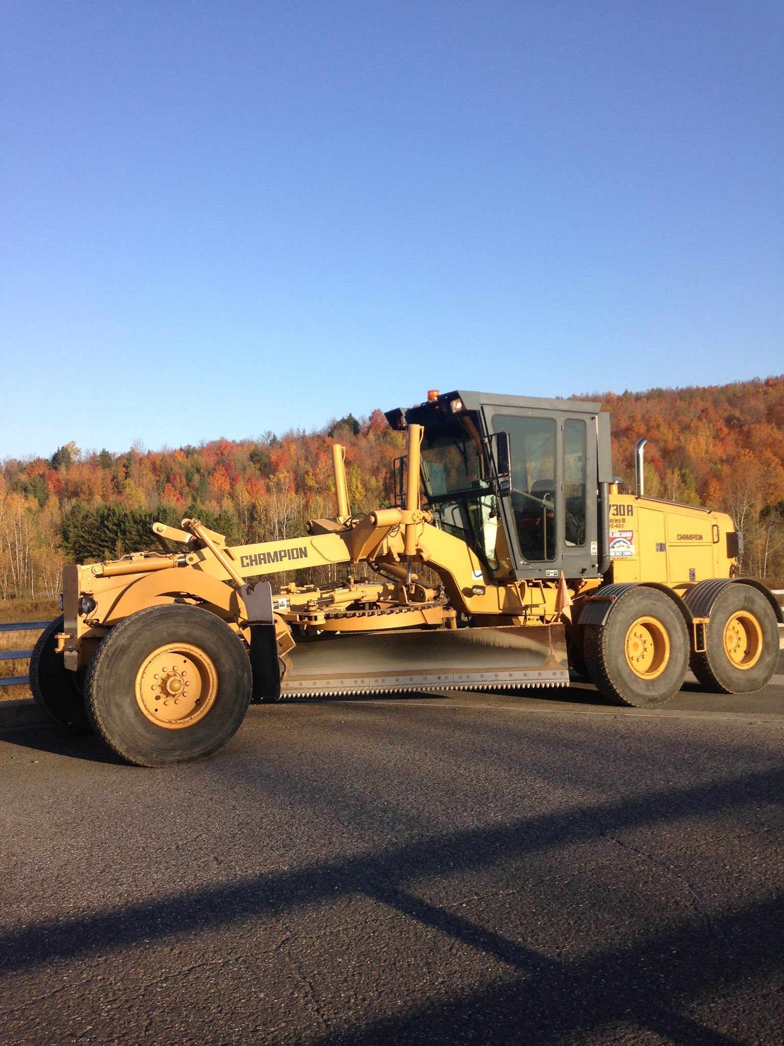 Un tracteur jaune est garé sur le bord de la route.