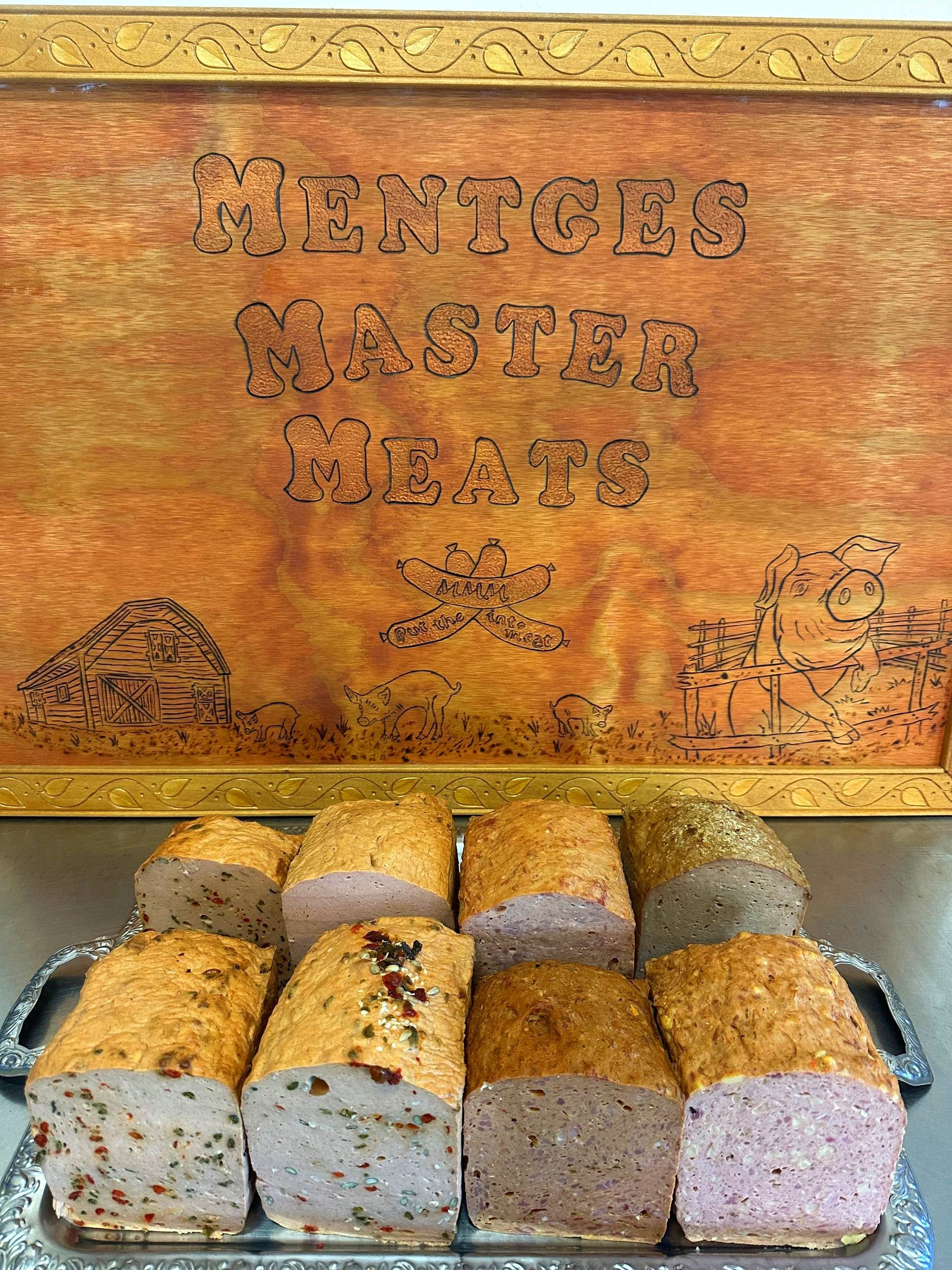 A Plate of Baked Meat Loaf Varieties With Tomatoes and Parsley — Mentges Master Meats Traditional Continental Smallgoods In Taree, NSW