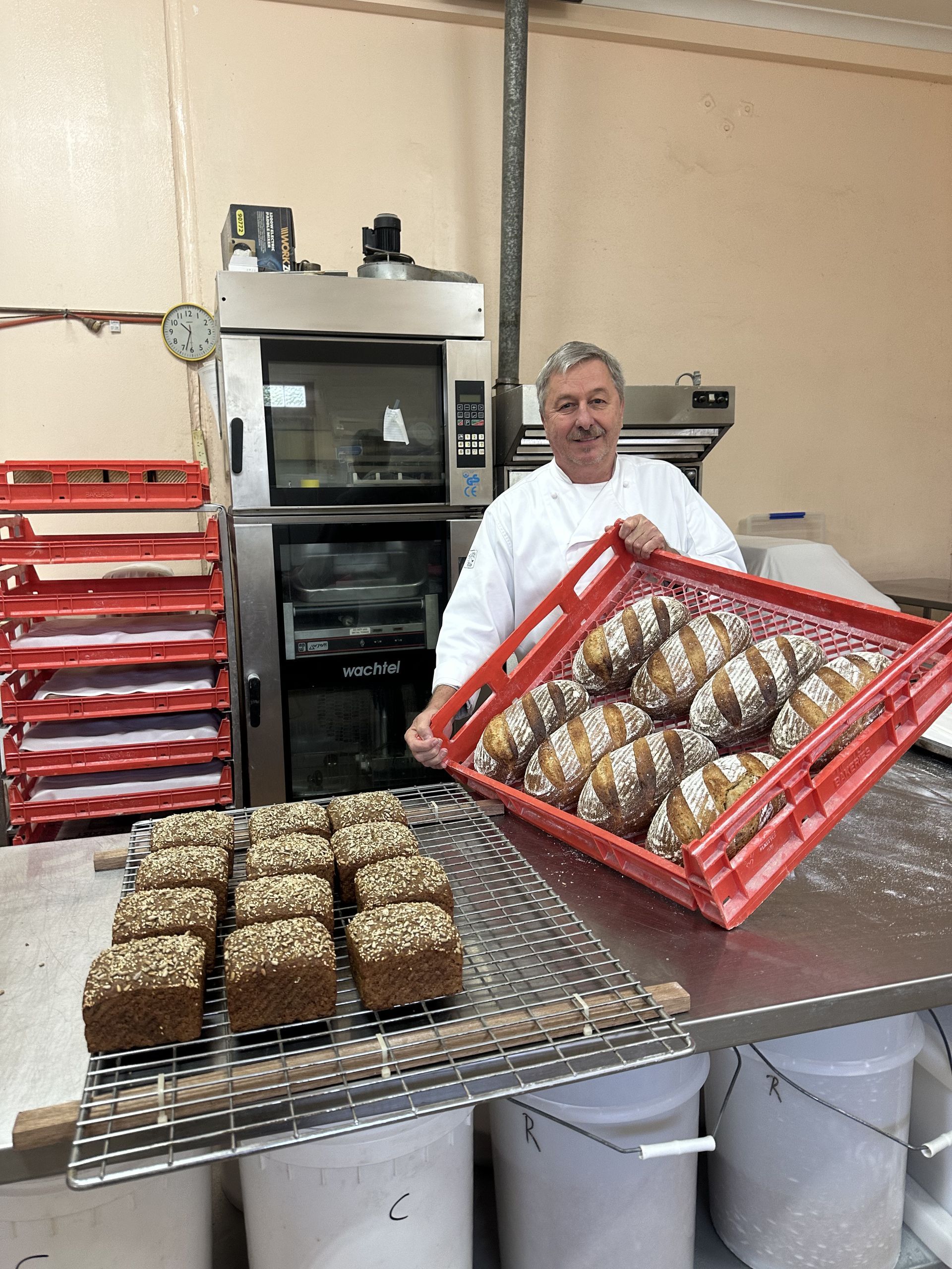 Two Loaves of Bread Are Sitting on Top of Each Other on A Cooling Rack — Mentges Master Meats Traditional Continental Smallgoods In Taree, NSW