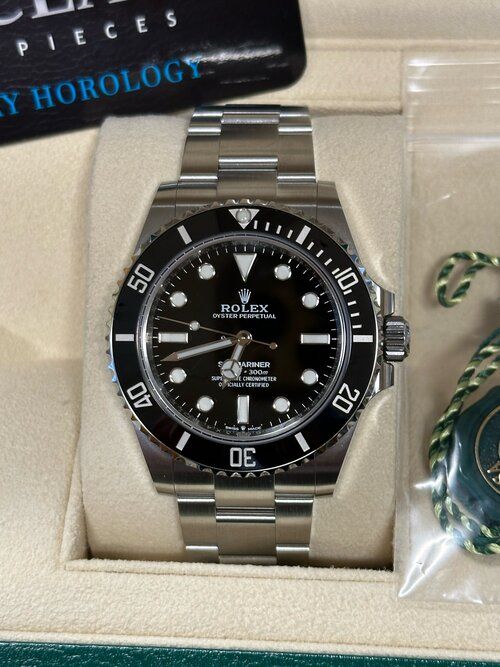 A black and silver rolex watch is in a box