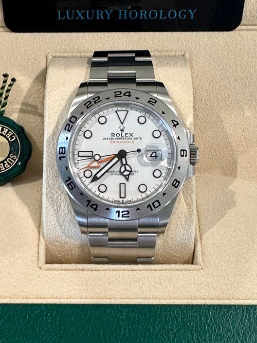 A silver rolex watch is sitting in a box